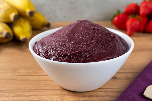 Brazilian frozen aÃ§ai berry ice cream bowl. with fruits on wooden background.