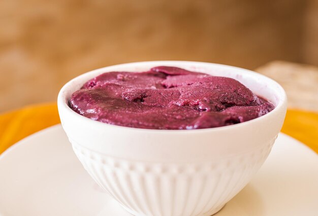 Brazilian frozen acai served in white bowl on wooden board