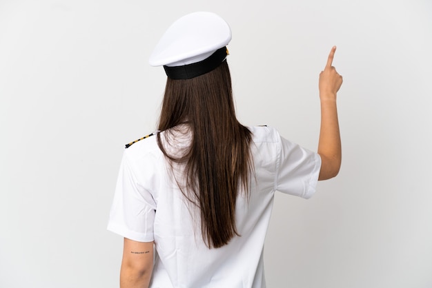 Brazilian girl Airplane pilot over isolated white background pointing back with the index finger