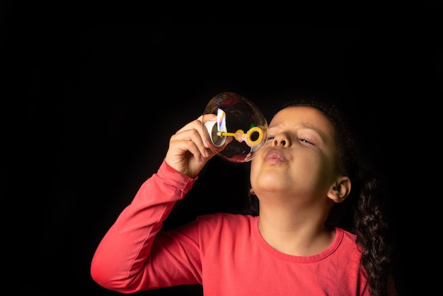 Brazilian girl with pink top playing soap bubbles