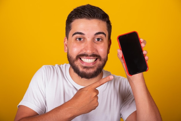 Brazilian Latin American man with hand pointing to cellphone cellphone screen for app communication