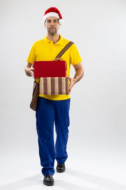 Brazilian mailman dressed as Santa Claus delivering a gift on a white background. copy space.