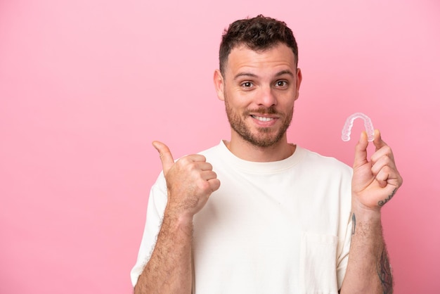 Brazilian man holding invisible braces pointing to the side to present a product