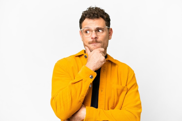 Brazilian man over isolated white background having doubts and thinking