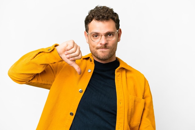 Brazilian man over isolated white background showing thumb down with negative expression