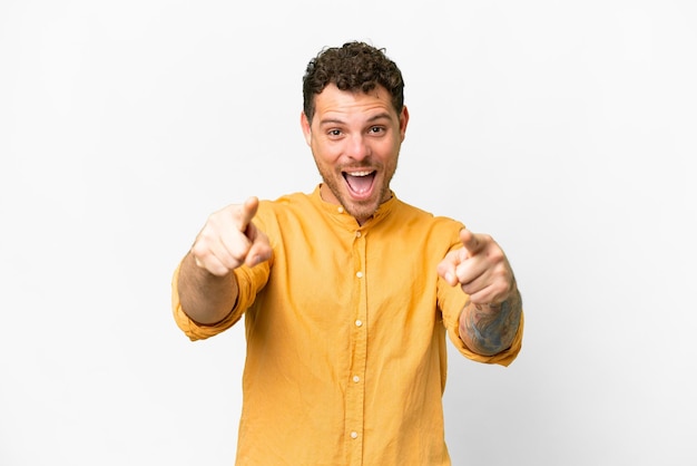 Brazilian man over isolated white background surprised and pointing front