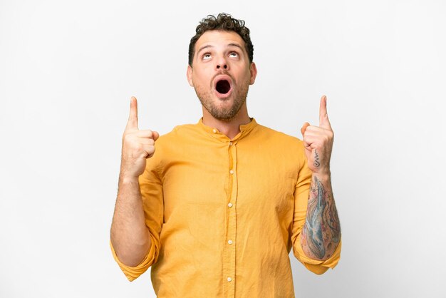 Brazilian man over isolated white background surprised and pointing up