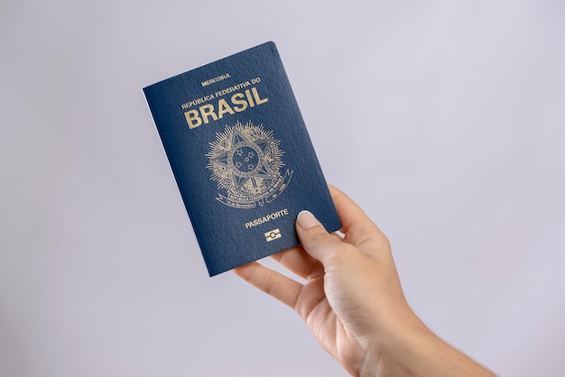 Brazilian passport in a hand with white background