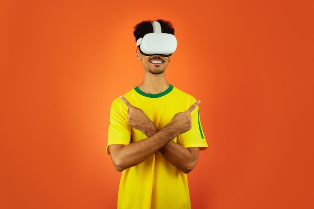 Brazilian Player Black Man Celebrating With VR Virtual Glasses Isolated on Orange background