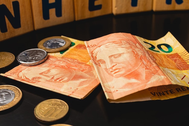 Brazilian real banknotes and coins on a dark table