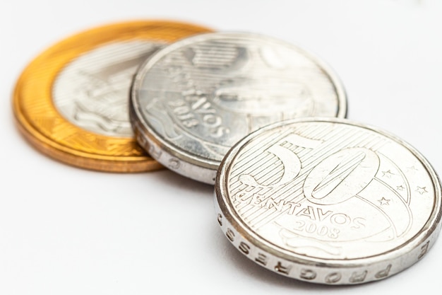 Brazilian Real coins on white paper in macro photography for finance and savings concept