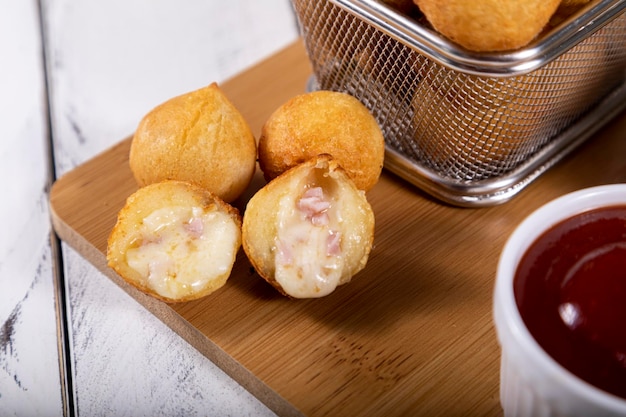 Brazilian snacks fried balls stuffed with ham and cheese Selective focus