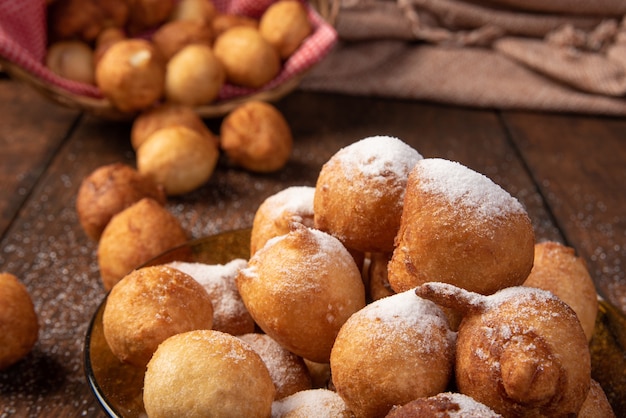 Brazilian sweet called bolinho de Chuva, covered with sugar, over rustic wood