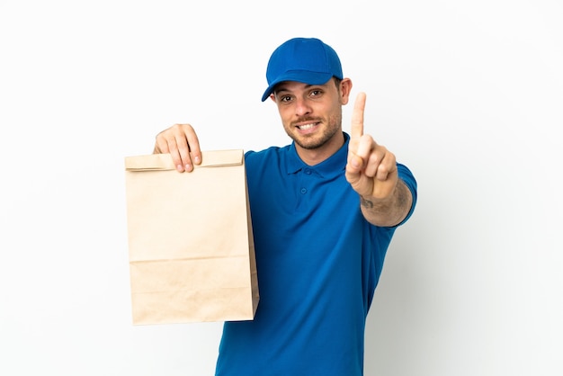 Brazilian taking a bag of takeaway food isolated on white background showing and lifting a finger