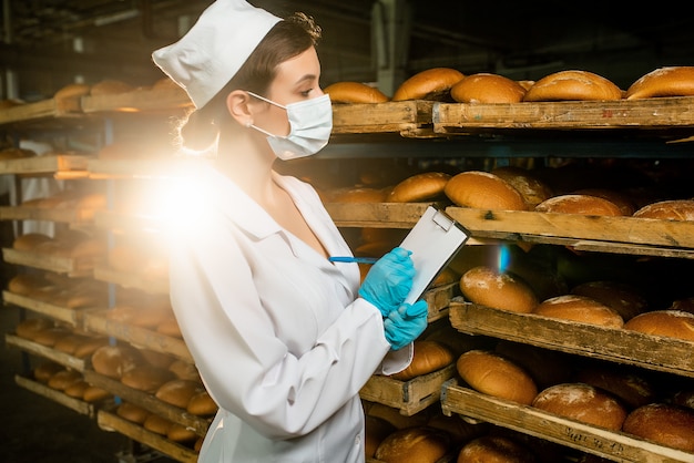 Bread. Bread production line. woman in uniform. Sanitary check.