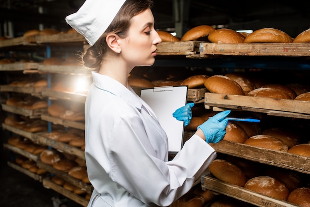 Bread. Bread production line. woman in uniform. Sanitary check.