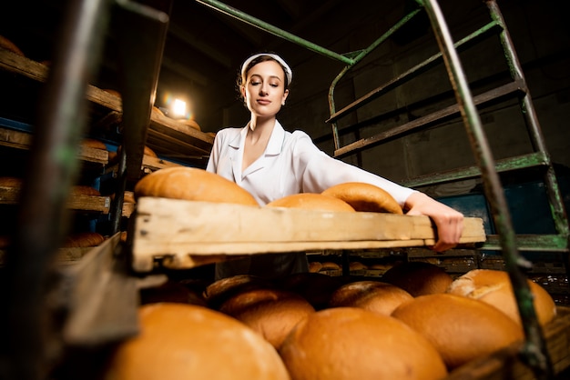 Bread. Bread production line. woman in uniform. Sanitary check.