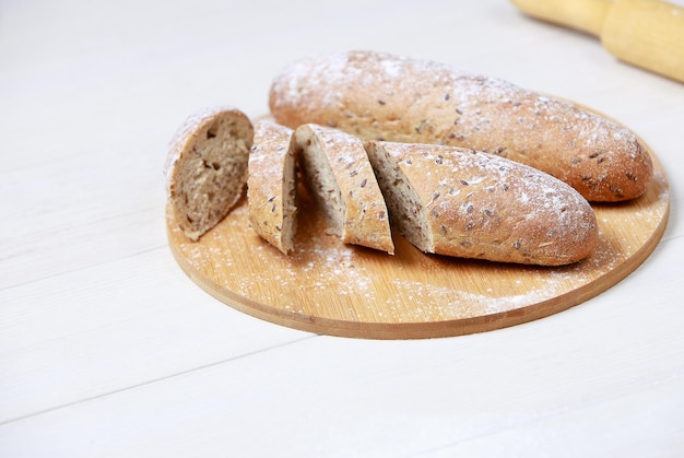 Bread on a cutting Board. Whole-grain rye bread. On light wooden table