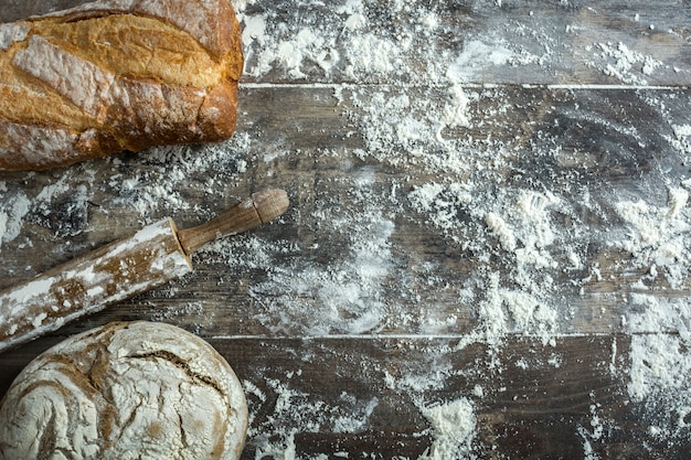 Bread and flour on a rustic wooden background copy space