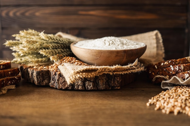 Bread grains ears of wheat and flour on a wooden background bakery advertising banner