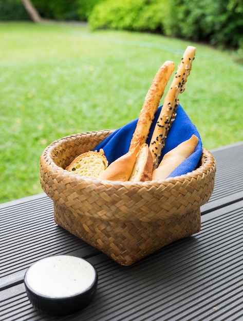 Bread loaf food snack in basket with blue napkin and white sauce at morning