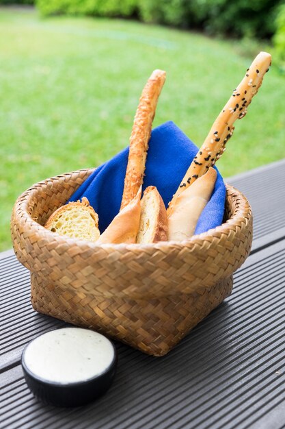 Bread loaf food snack in basket with blue napkin and white sauce