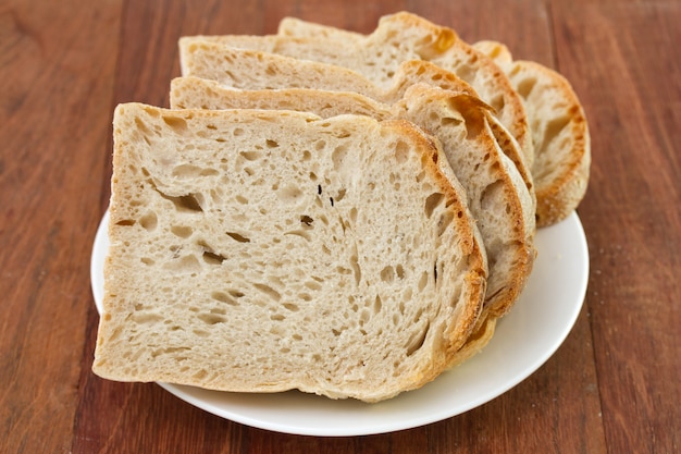 Bread on plate on brown background