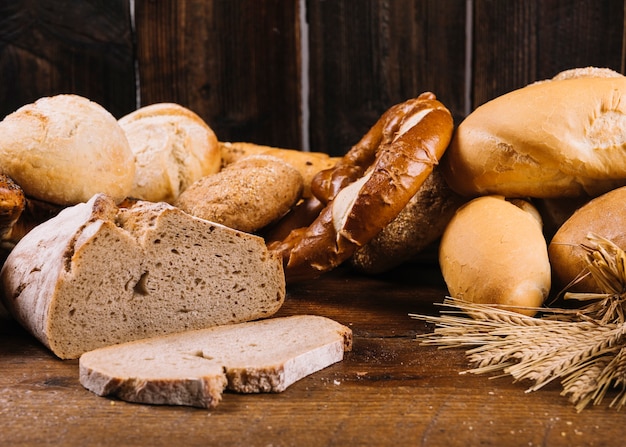 Bread slice and baked whole grain bread on wooden table