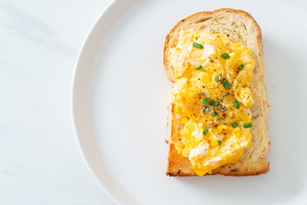 Photo bread toast with scramble egg on white plate