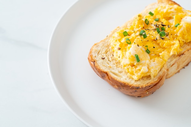 bread toast with scramble egg on white plate