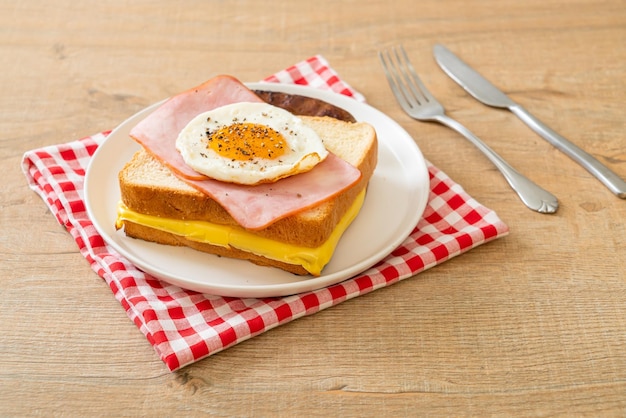 Bread toasted cheese topped ham and fried egg with pork sausage