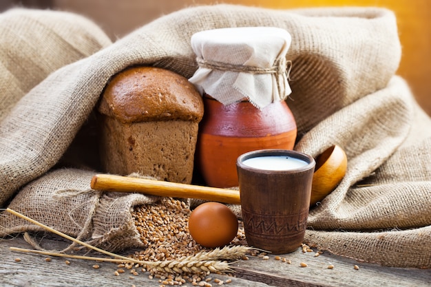 Bread and wheat grains on a wooden background