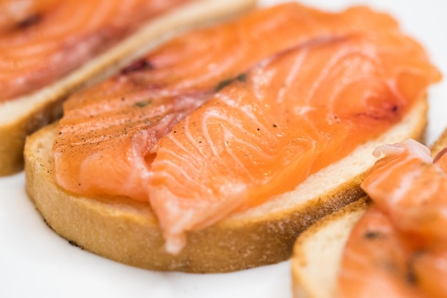 Bread with fresh salted salmon fillet isolated on white background top view