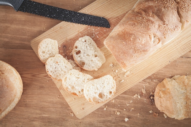 Bread with a knife on the chopping board.