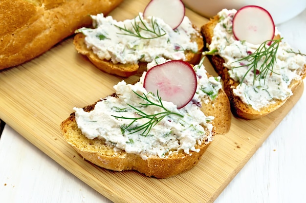 Bread with pate of curd and radish on light board