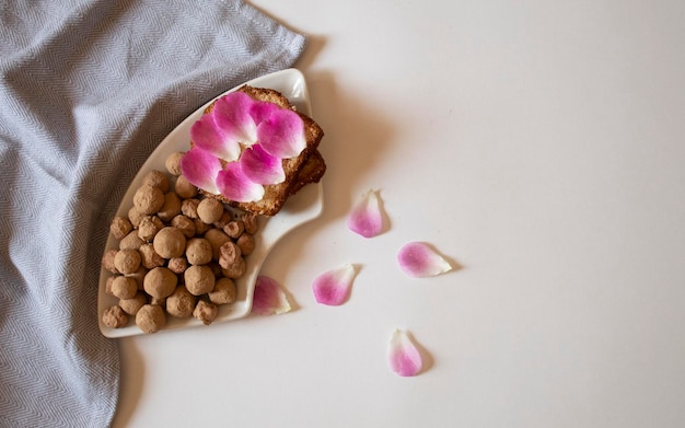 Bread with pink rose petals and edible clay stones flat lay