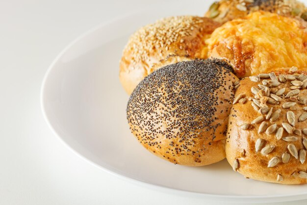 Bread with sesame poppy sunflower pumpkin seeds and cheese on white plate selective focus