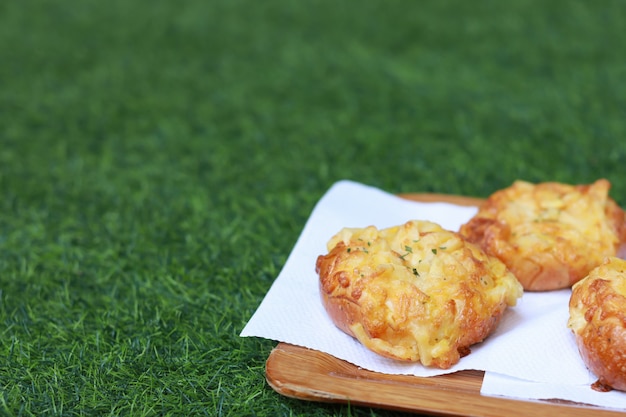 Bread on wooden plate and green grass