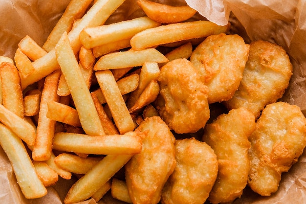 Breaded chicken fillet and french fries Served in a wicker basket on craft paper