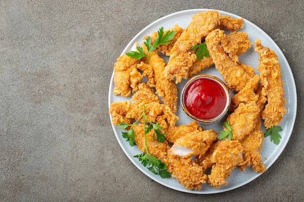 Breaded chicken strips with sauce.