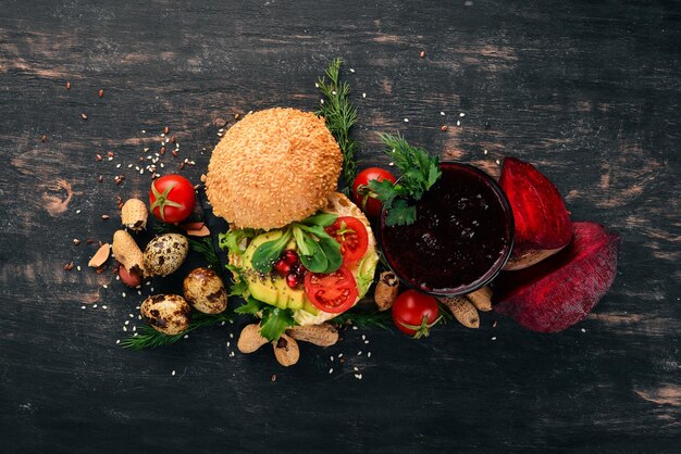 Breakfast Beetroot juice and avocado burger and vegetables On a wooden background Top view Copy space