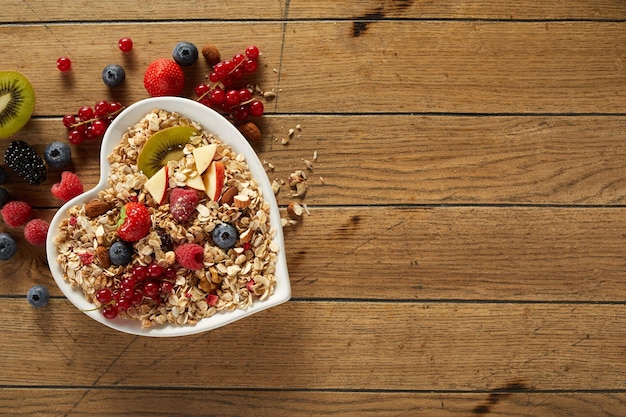 Photo breakfast bowl with oat and berries on table