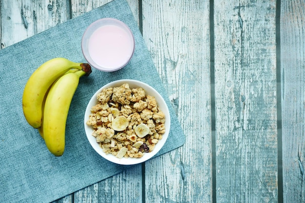 Breakfast cereal banana and milk on table with copy space