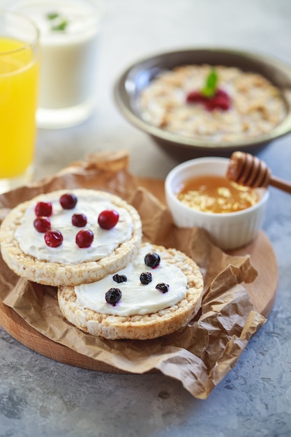 Breakfast. Cereal bread with cottage cheese and berries, with granola and orange juice and natural yogurt. Proper and healthy nutrition.