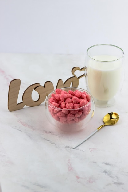 Breakfast cereal with strawberry flavor A bowl of snacks in the shape of hearts on a white marble table Romantic breakfast