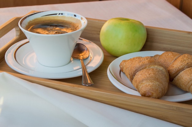 Breakfast of coffee Apple croissants on wooden tray