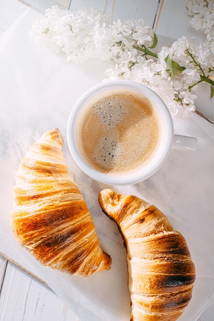 Breakfast concept hot and fresh croissant and a cup of coffee