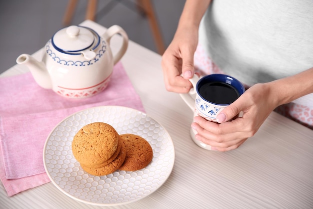 Breakfast concept Woman with cup of tea in kitchen