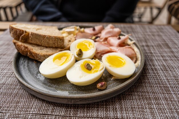 A breakfast dish with eggs and bacon on a table in a cafe outdoors