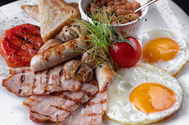 Breakfast. Eggs, bacon, mushrooms, toast, beans, on a white plate